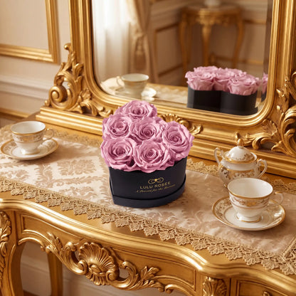 LULU ROSÉE baby heart box light pink roses black classic box displayed on an ornate table with a mirror in the background