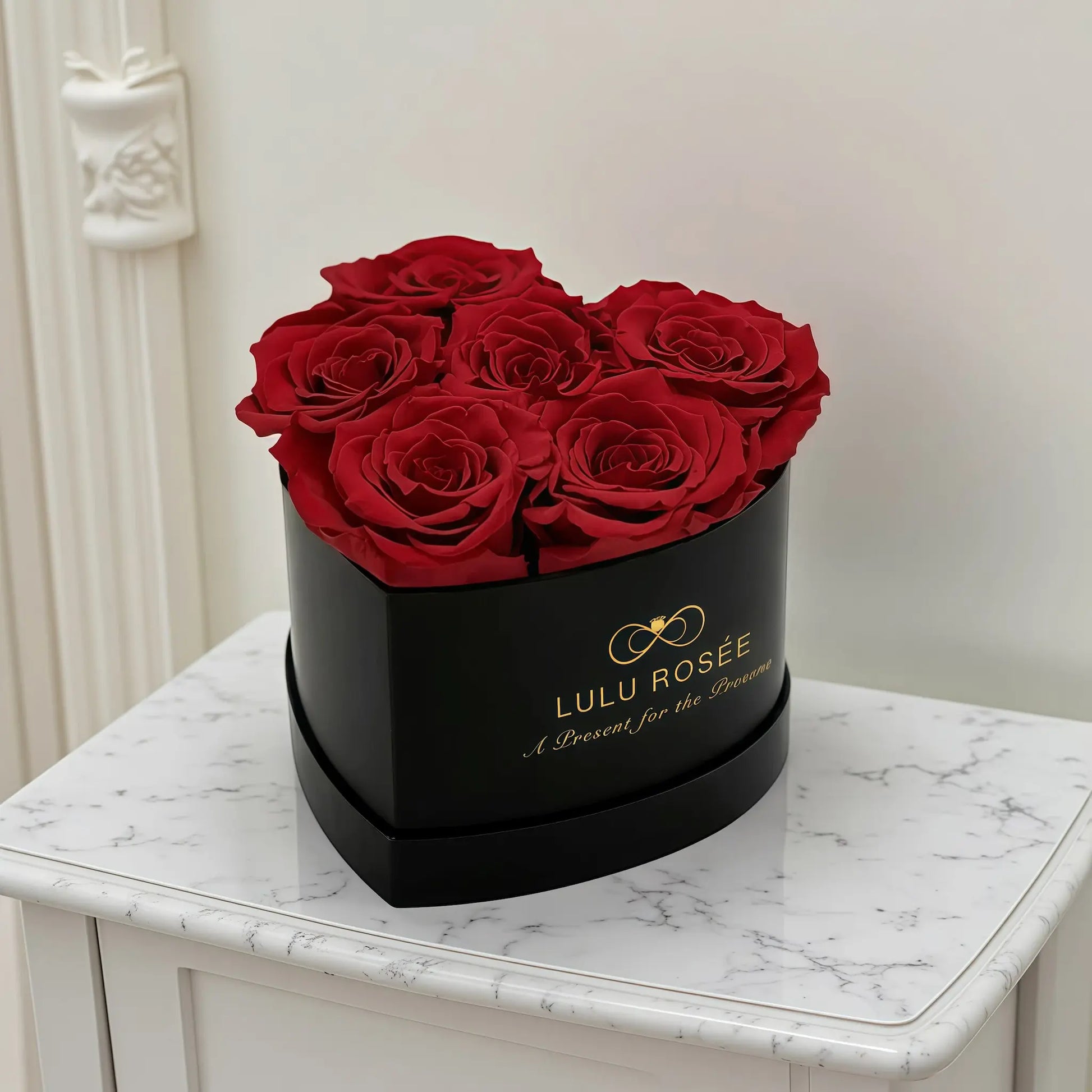 LULU ROSÉE baby heart box red roses black classic box displayed on a gift table