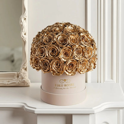 LULU ROSÉE superdome box gold roses  beige box on a decorative surface.