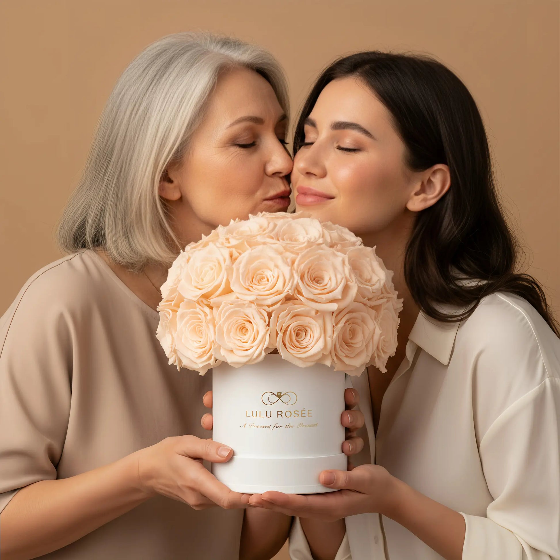 Two women holding a bouquet of pink roses in a white box with 'LULU ROSÉE ' branding