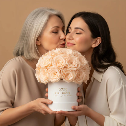 Two women holding a bouquet of pink roses in a white box with 'LULU ROSÉE ' branding