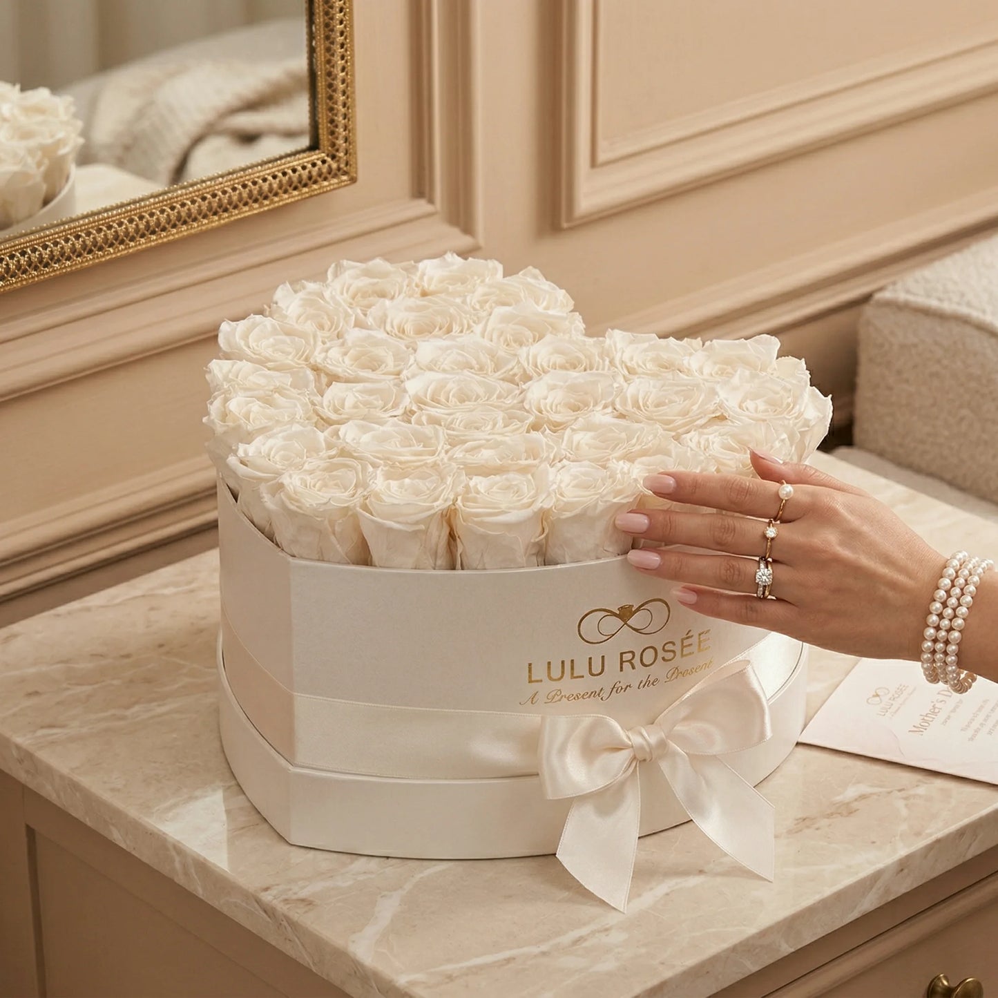 Heart-shaped box of white roses with 'Lulu Rosée' branding on a marble surface.