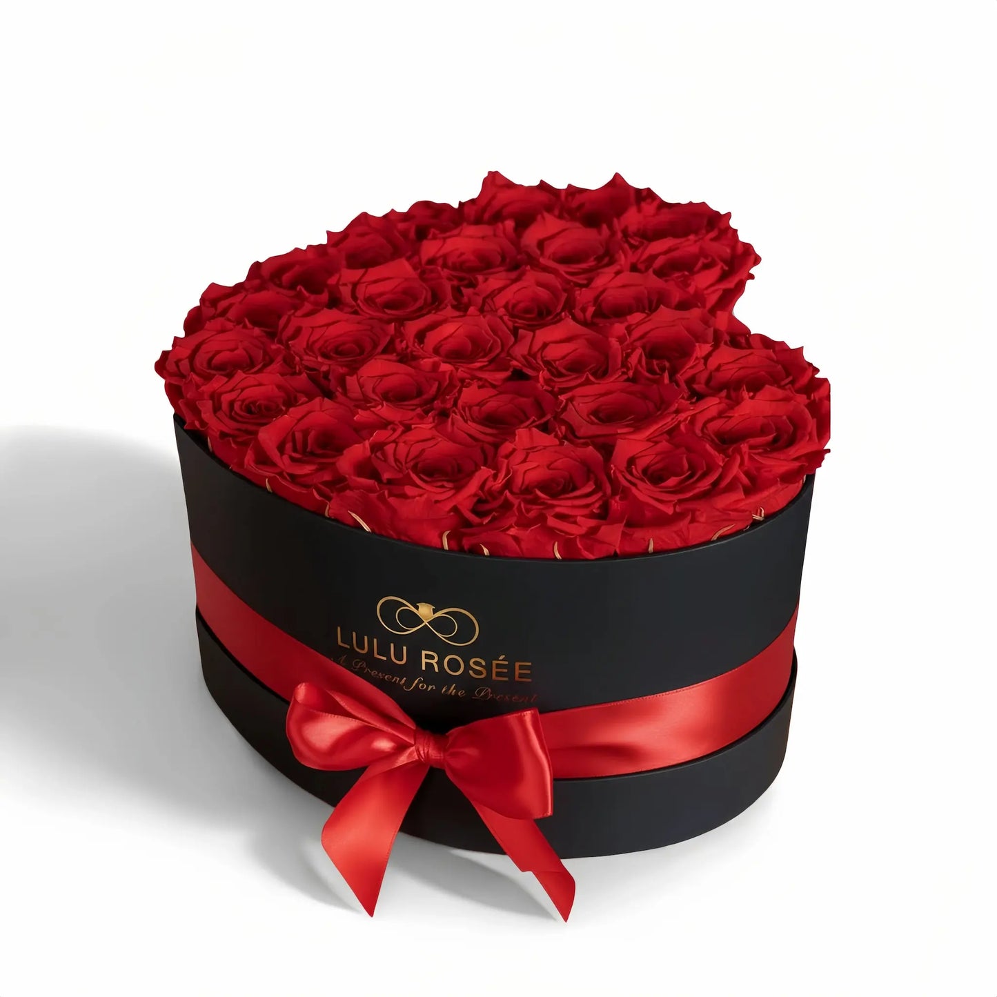 Heart-shaped box of red roses with a red ribbon and Lulu Rosée branding on a white background