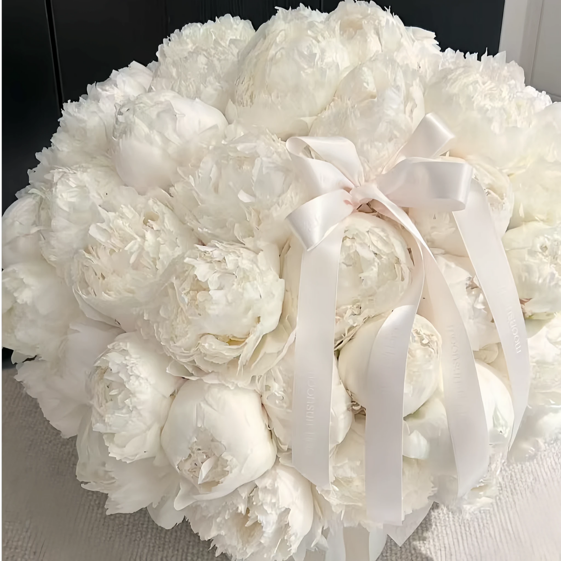 LULU ROSÉE Moonlight Peony Round Box indoor scene, full view ivory preserved peonies with soft satin bow, luxury white preserved flower decor