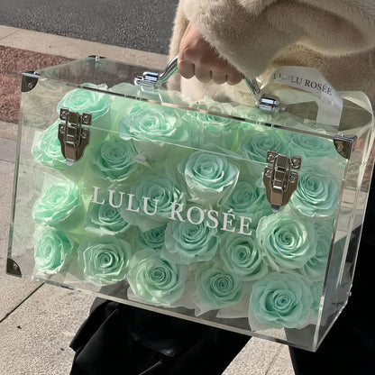 LULU ROSÉE Moyenne Eternal Acrylic Handbag Rose Box, medium transparent acrylic handbag-shaped gift box filled with mint green preserved roses, outdoor lifestyle handheld display, customizable flower colors, elegant everlasting floral gift for birthdays, anniversaries & romantic celebrations