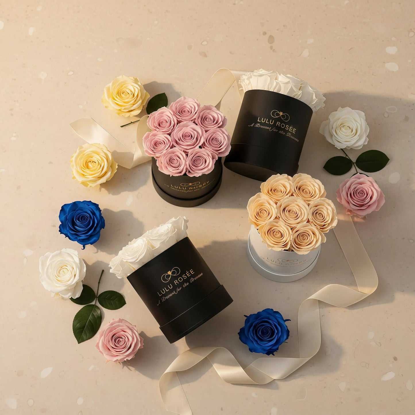 Assorted flowers in decorative boxes on a beige surface with visible branding.