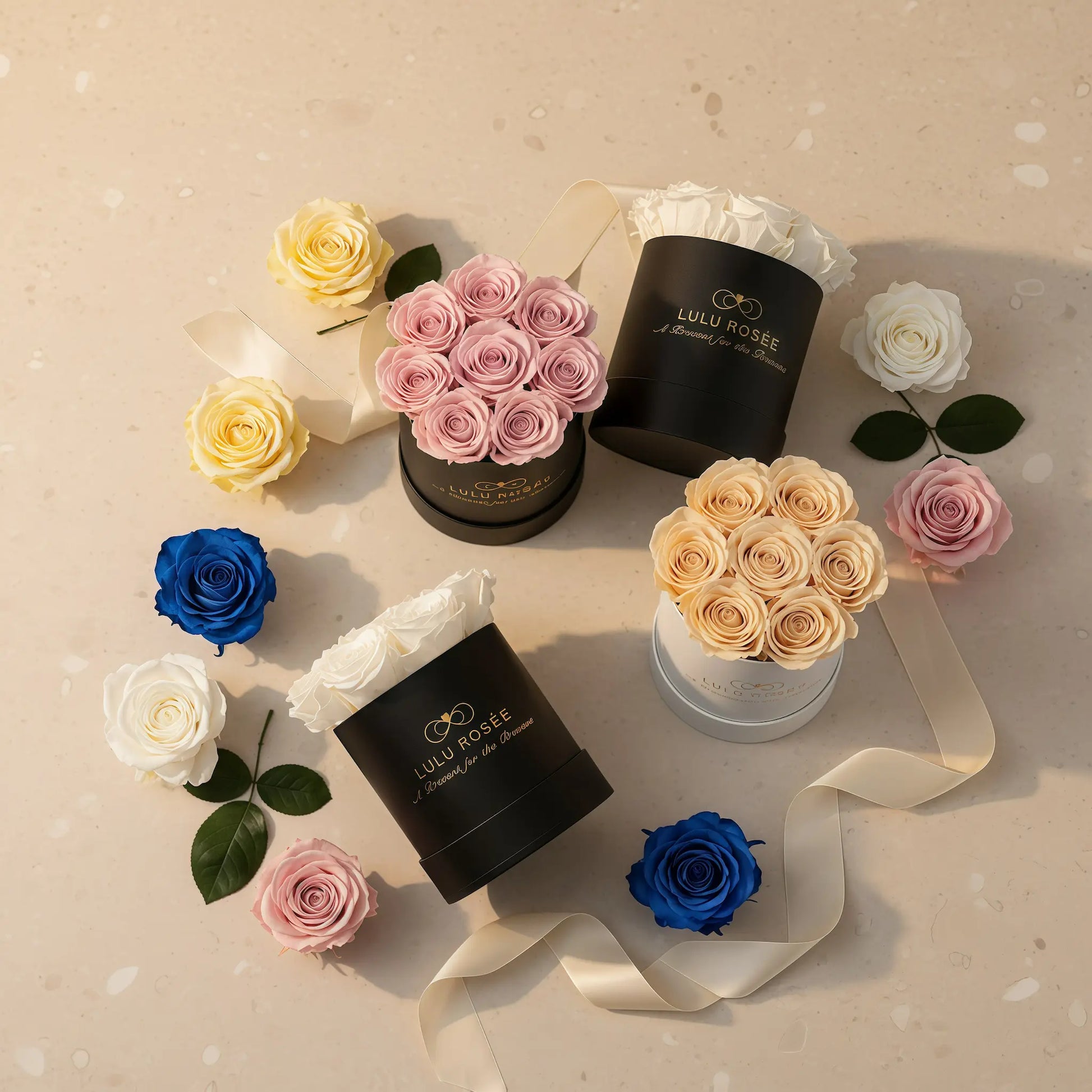 Assorted flowers in decorative boxes on a beige surface with visible branding.